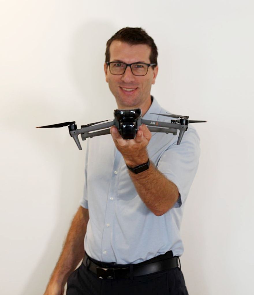 Bernd Broschek BEd mit moderner Drohne vor weißem Hintergrund – Drohnenflüge Kärnten